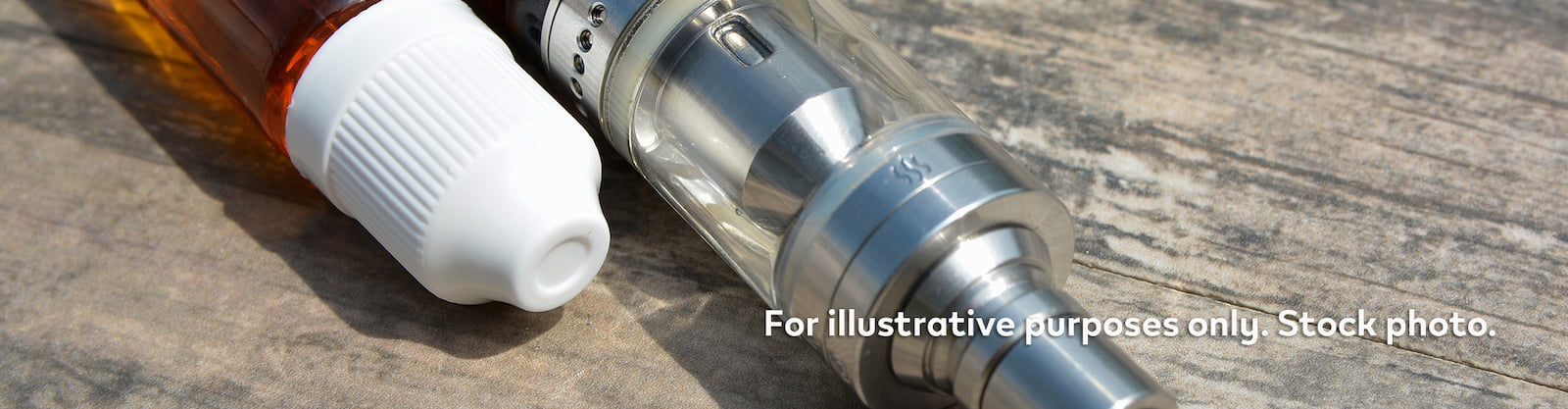 Vape next to bottle of e-liquid